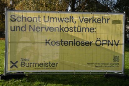 Bauzaun Schont Umwelt, Verkehr und Nervenkostüme: Kostenloser ÖPNV